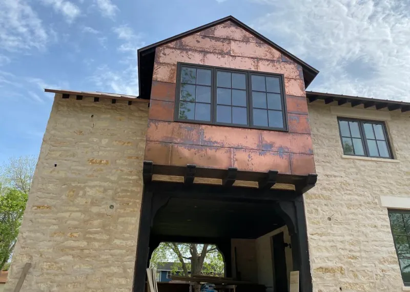 Copper metal panel facade on a stone building for Roof Repair in Crystal