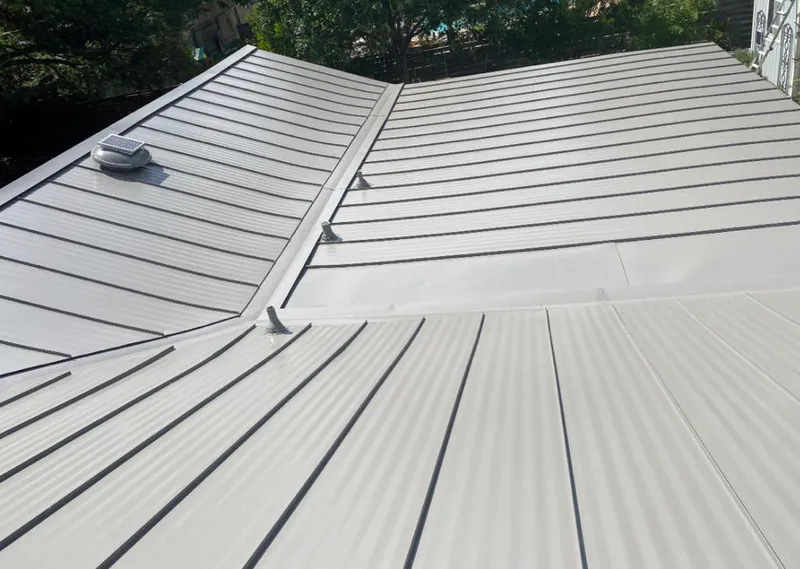 Solar attic fan installed on a metal roof for Roof Ventilation in Crystal